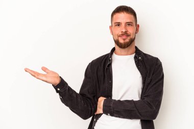 Beyaz arka planda izole edilmiş beyaz tenli genç beyaz adam bir avuç içinde fotokopi alanı ve belinde başka bir el tutuyor..