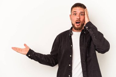 Beyaz arka planda izole edilmiş beyaz tenli genç beyaz adam palmiye üzerinde kopya alanı bulundurmaktan etkilenmiş..