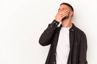 Diastemalı genç beyaz adam beyaz arka planda yalnız gülüyor, kaygısız, doğal duygulara sahip..