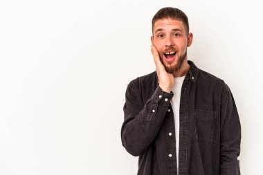 Beyaz arka planda izole edilmiş beyaz tenli genç beyaz adam yüksek sesle bağırıyor, gözleri açık ve elleri gergin tutuyor..