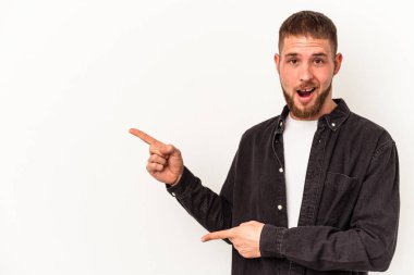 Diastema 'lı genç beyaz arka planda izole edilmiş, işaret parmaklarıyla fotokopi alanını işaret eden, heyecan ve arzuyu ifade eden beyaz bir adam..