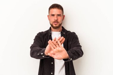 Beyaz arka planda izole edilmiş beyaz tenli genç beyaz bir adam elini uzatmış, dur işareti göstererek seni engelliyor..