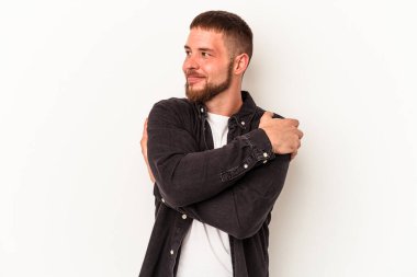 Diastemalı genç beyaz adam beyaz arka plan kucaklamalarında izole edilmiş, güler yüzlü ve mutlu..