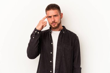 Diastema 'lı beyaz arka planda izole edilmiş beyaz tenli genç beyaz bir adam parmağıyla tapınağı işaret ediyor, düşünüyor ve bir göreve odaklanıyor..