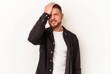 Beyaz arka planda izole edilmiş beyaz tenli genç beyaz bir adam bir şeyi unutuyor. Alnına avuç içi ve kapalı gözlerle vuruyor..