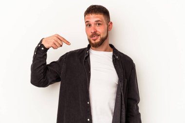 Diastemalı beyaz tenli genç adam beyaz arka planda izole edilmiş gömlek fotokopi alanını işaret ediyor, gururlu ve kendinden emin.