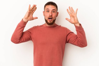 Diastema 'lı beyaz arka planda izole edilmiş genç beyaz bir adam zaferi veya başarıyı kutluyor, şaşırıyor ve şok oluyor..