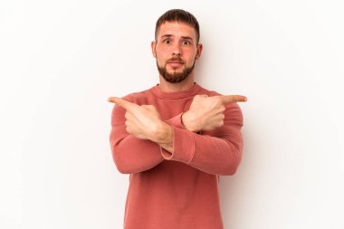 Diastemalı genç beyaz arka plan noktalarında izole edilmiş beyaz bir adam iki seçenek arasında seçim yapmaya çalışıyor..