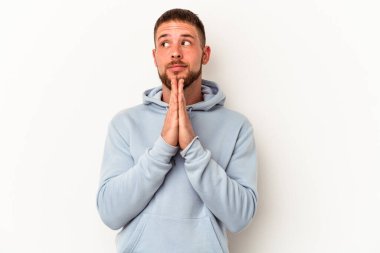 Diastemalı genç beyaz adam beyaz arka planda izole edilmiş dua ediyor, kendini adamış, ilahi ilhamı arayan dindar biri..