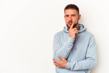 Diastema 'lı genç beyaz arka planda izole edilmiş şüpheli ve şüpheci bir ifadeyle yana bakan beyaz bir adam..