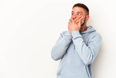 Diasteması olan beyaz tenli genç bir adam beyaz arka planda izole edilmiş. Ağzını eliyle kapatan bir fotokopi odasına bakıyor..