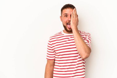 Beyaz arka planda izole edilmiş beyaz tenli genç beyaz adam yüzünün yarısını palmiye ile kaplayarak eğleniyor..
