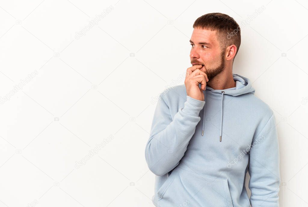 Young caucasian man with diastema isolated on white background relaxed thinking about something looking at a copy space.