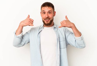 Beyaz arka planda izole edilmiş diyastemalı genç beyaz adam parmaklarıyla bir cep telefonu hareketi gösteriyor..