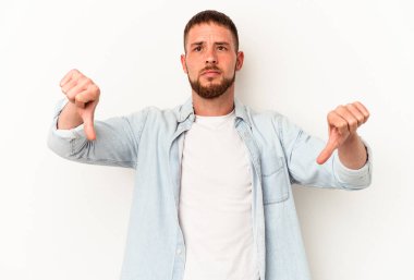 Diastemalı beyaz bir adam beyaz arka planda izole edilmiş. Sevimsiz bir jest gösteriyor. Başparmakları aşağıda. Anlaşmazlık konsepti.