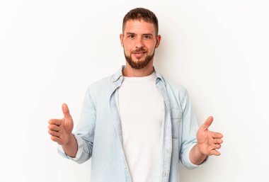 Diastemalı beyaz bir adam beyaz arka planda iki eliyle bir şey tutuyor, ürün sunumu..