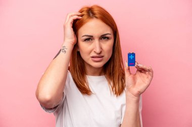 Pembe arka planda pil tutan genç beyaz kadın şok geçiriyordu. Önemli bir toplantıyı hatırladı..