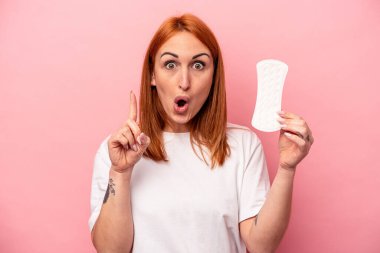 Elinde hijyenik peçete tutan beyaz bir kadın. Pembe arka planda izole edilmiş. Harika bir fikir, yaratıcılık kavramı var..