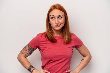 Beyaz arka planda soyutlanmış beyaz bir kadın kafası karışmış, kuşkulu ve kendinden emin değil..