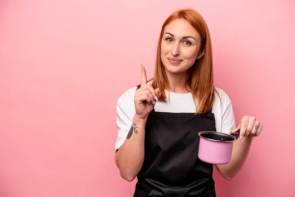 Młody Kaukaski Kuchenka Kobieta Gospodarstwa Tłumacz Izolowany Różowy Tło Pokazując — Zdjęcie stockowe