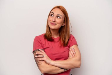 Beyaz arka planda izole edilmiş genç beyaz kadın hedeflere ve amaçlara ulaşmayı hayal ediyor.