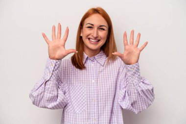 Beyaz arka planda izole edilmiş beyaz tenli genç kadın on numarayı elleriyle gösteriyor..