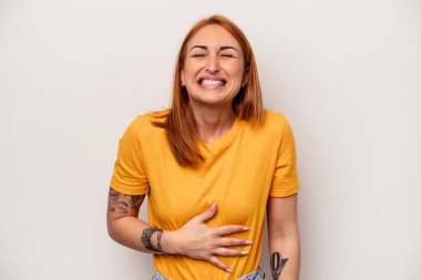 Beyaz arka planda izole genç beyaz kadın karnına dokunuyor, nazikçe gülümsüyor, yemek yiyor ve tatmin oluyor..