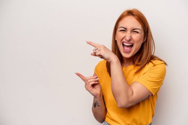 Beyaz arka planda izole edilmiş beyaz tenli genç bir kadın işaret parmağıyla işaret ederek heyecanlanıyor..