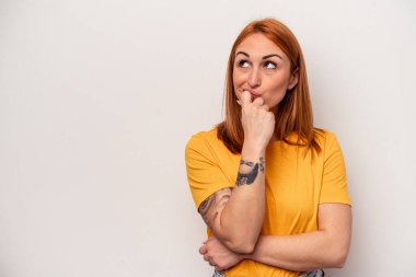 Beyaz arka planda izole edilmiş genç beyaz kadın rahatlamış bir şeyin fotokopi odasına baktığını düşünüyor..