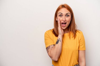 Beyaz arka planda izole genç beyaz kadın yüksek sesle bağırıyor, gözleri açık ve elleri gergin tutuyor..