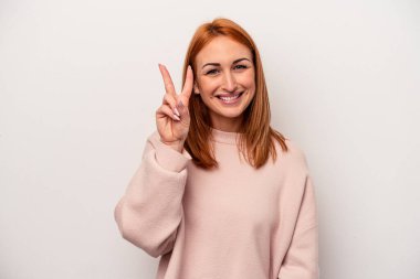 Beyaz arka planda izole edilmiş genç beyaz kadın iki numarayı parmaklarıyla gösteriyor..