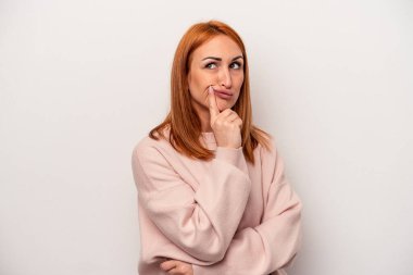 Beyaz arka planda izole edilmiş beyaz bir kadın mutsuz bir şekilde alaycı bir ifadeyle kameraya bakıyor..