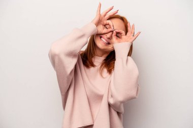 Beyaz arka planda izole edilmiş beyaz tenli genç bir kadın gözlerinde sorun olmadığını gösteriyor.