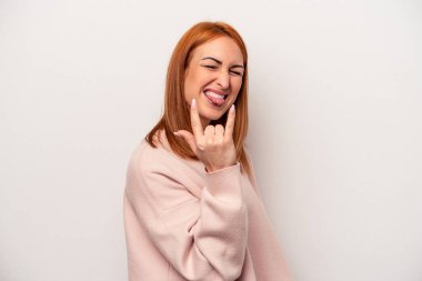 Beyaz arka planda izole edilmiş genç beyaz kadın parmaklarıyla taş hareketi gösteriyor.