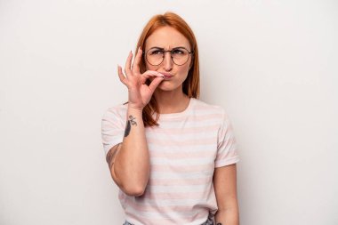 Beyaz arka planda izole edilmiş beyaz tenli genç bir kadın parmakları dudaklarında bir sır saklıyor..