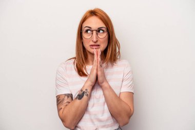 Beyaz arka planda izole edilmiş genç beyaz kadın dua ediyor, bağlılık gösteriyor, dindar biri ilahi ilhamı arıyor..
