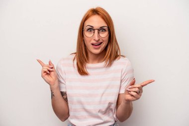 Beyaz arka planda izole edilmiş genç beyaz kadın farklı kopya alanlarını gösteriyor, birini seçiyor, parmaklarıyla gösteriyor.