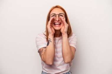 Beyaz arka planda izole edilmiş genç beyaz bir kadın bir dedikodu söylüyor, bir haber sunuyor..