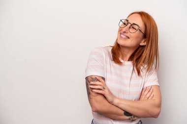 Beyaz arka planda soyutlanmış beyaz bir kadın kollarını kavuşturup gülümsüyor..