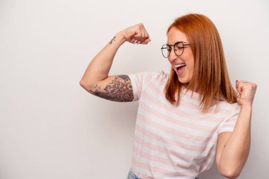 Beyaz arka planda izole genç beyaz kadın zafer kazandıktan sonra yumruğunu kaldırıyor, kazanan konsept..