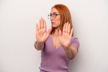 Beyaz arka planda izole edilmiş genç beyaz bir kadın elini uzatmış, dur işareti göstererek seni engelliyor..