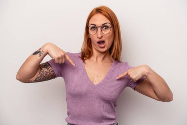 Beyaz arka planda izole genç beyaz kadın parmaklarıyla aşağı noktalar, olumlu duygu.