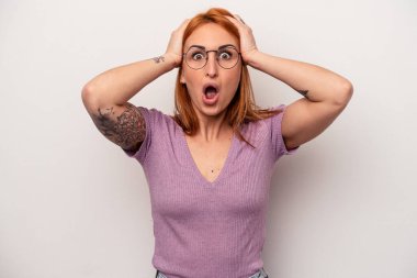 Beyaz arka planda izole edilmiş genç beyaz kadın şaşırmış ve şok olmuş..
