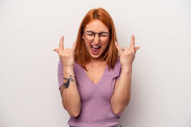 Beyaz arka planda izole edilmiş genç beyaz kadın boynuzlarını devrim konsepti olarak gösteriyor..