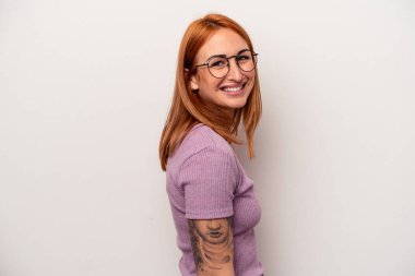 Beyaz arka planda izole edilmiş beyaz tenli genç bir kadın ellerini kalçasından ayırmıyor..