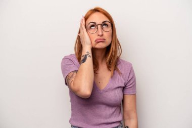 Beyaz arka planda izole edilmiş genç beyaz kadın yorgun ve uykulu ellerini başının üstünde tutuyor..