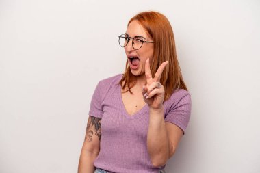 Beyaz arka planda izole edilmiş genç beyaz kadın iki numarayı parmaklarıyla gösteriyor..