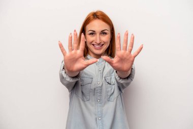 Beyaz arka planda izole edilmiş beyaz tenli genç kadın on numarayı elleriyle gösteriyor..