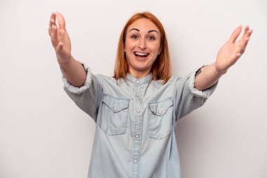 Beyaz arka planda izole genç beyaz kadın zaferi ya da başarıyı kutluyor, şaşırıyor ve şok oluyor..