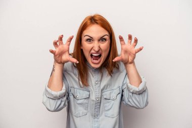 Beyaz arka planda izole edilmiş genç beyaz kadın pençelerini kedi taklidi yaparken gösteriyor, agresif bir hareket..